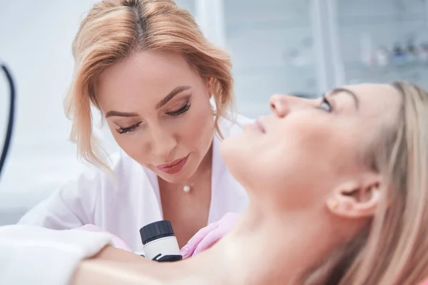 Konzentrierte qualifizierte Dermatologin mittleren Alters, die Dermatoskopie durchführt — Stockfoto