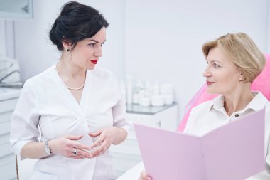 Kibar kozmetikçi müşterisine kaldırma konusunda danışıyor.