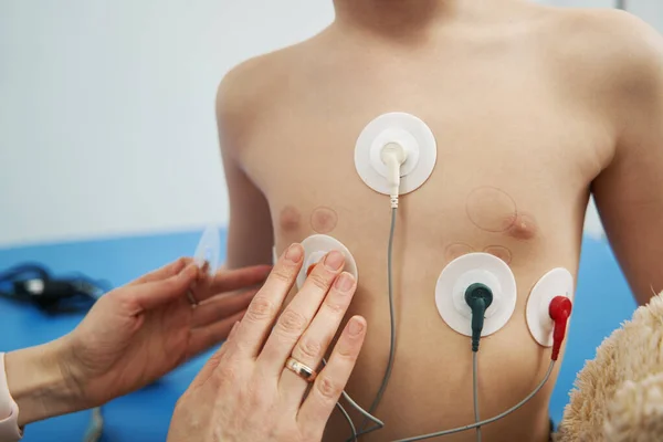 Dokter memeriksa irama jantung anak dengan monitor holter ECG — Stok Foto