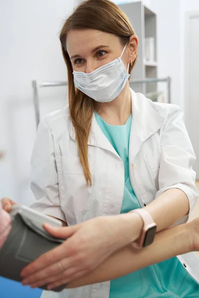 診療所で患者の血圧をチェックする女性医師 — ストック写真