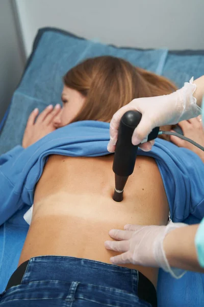 Mujer que recibe terapia extracorpórea de ondas de choque en la clínica — Foto de Stock