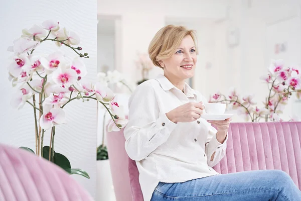 Cute mature blonde woman enjoying aroma coffee — Stock Photo, Image