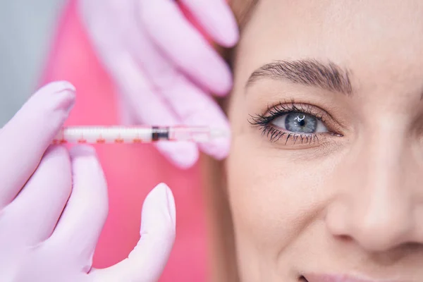 Aesthetic clinic client being treated for crows feet by dermatologist — Stock Photo, Image