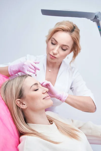 Konzentrierter Dermatologe verabreicht dem Klienten subkutane Injektionen — Stockfoto