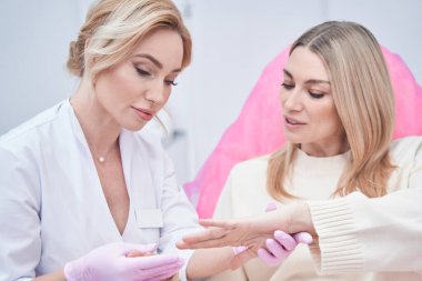 Cutaneous muayene prosedürü uygulayan konsantre profesyonel dermatolog.