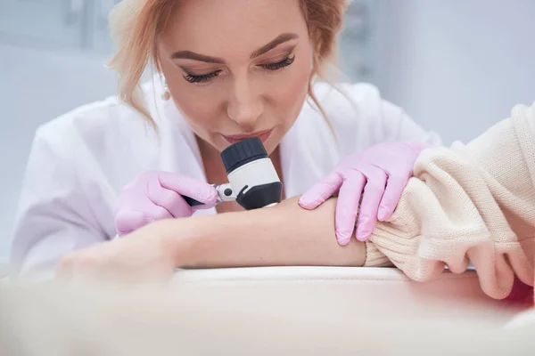 Concentrated dermatologist conducting patient skin check with dermoscope — Stock Photo, Image