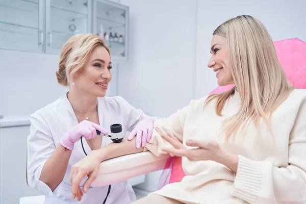 Glada patienten kommunicera med hudläkare under dermatoskopi — Stockfoto