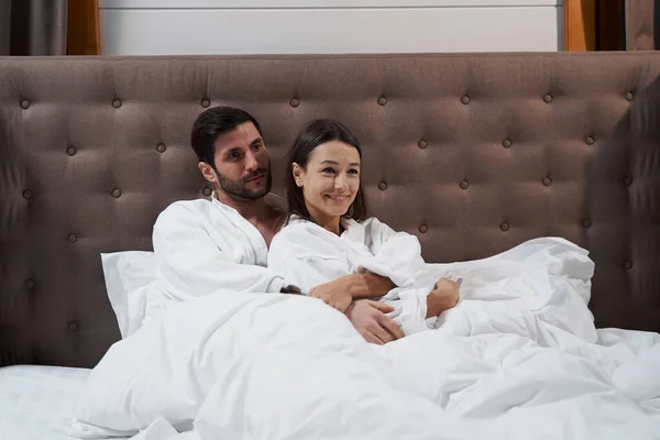 男人在旅馆房间的床上拥抱他的妻子 — 图库照片