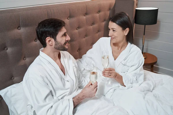 Felice coppia sposata bere champagne a letto — Foto Stock