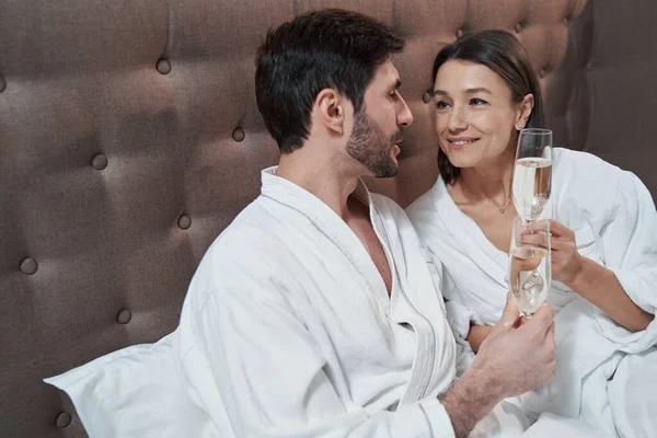 Alkol içerken erkeğin gözlerine bakan kadın.