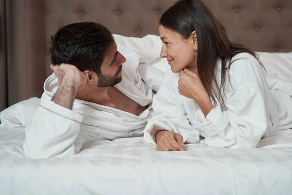 People in love talking while lying in bed — Stockfoto