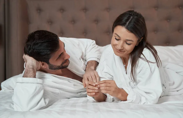Couple relaxing in bed of their hotel suite — 스톡 사진