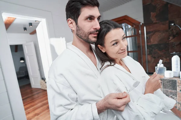 Otelde birbirine aşık bir çift dişlerini fırçalıyor.