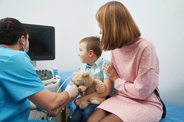 Caucasian boy with his mother at doctor appointment for vascular arm examination — Stockfoto