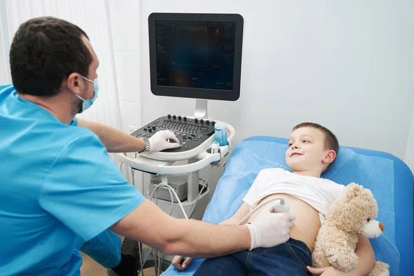Caucasian health worker performing an abdominal ultrasound on child — Fotografia de Stock