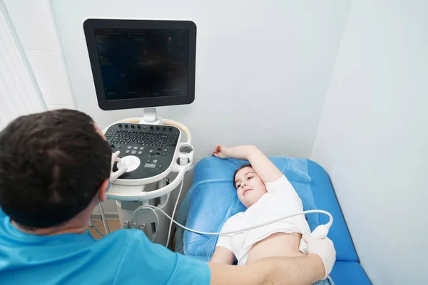 Caring health worker examining the result of kidney ultrasound on monitor — стоковое фото