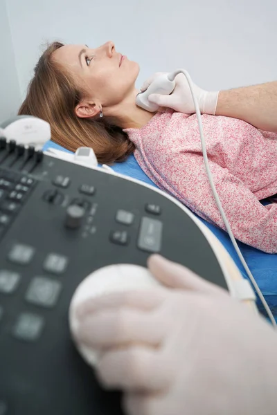 Сканування щитовидної залози жінки з Кавказу лежить на дивані в ендокринологічному бюро. — стокове фото
