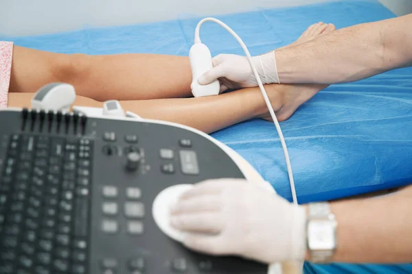 Medical specialist performing doppler ultrasound of the lower limb vessels — ストック写真