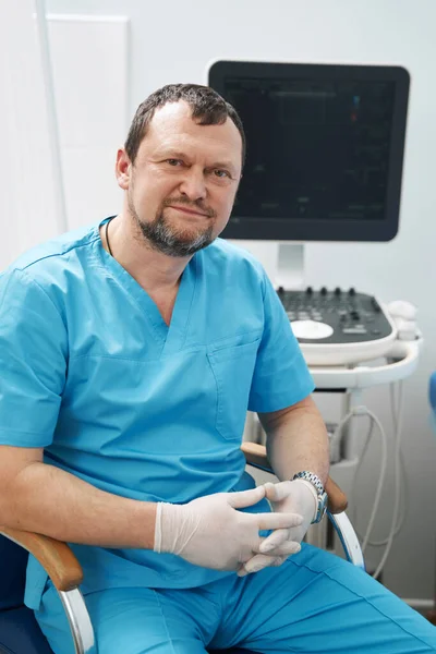 Joyous ultrasound technician sitting in his roomy office — Foto Stock