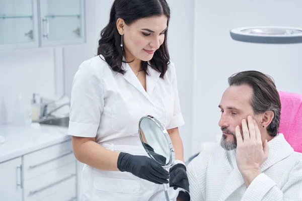 Aandachtige volwassen man op consultatie in schoonheidskliniek — Stockfoto