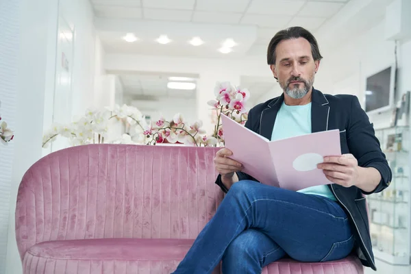 Fiyat listesine bakan ciddi bir erkek.