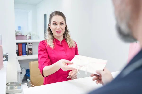 Positive delighted salon worker taking gift card — Foto Stock