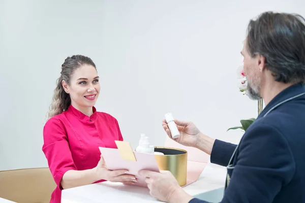 Aufmerksame erwachsene Mann Blick auf die Verpackung für Serum — Stockfoto