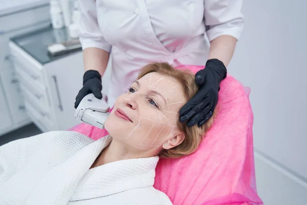 Woman having face lifting procedure in cosmetology clinic — ストック写真