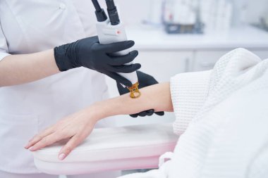 Güzellik uzmanı güzellik kliniğinde lazer tüy temizleme tedavisi uyguluyor.