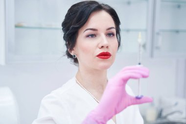 Şırıngaya bakan güzel bir pratisyenin portresi