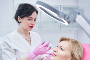 İşlem sırasında steril şırınga kullanan dikkatli bir tıp çalışanı.