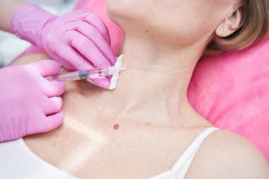 Steril şırınga tutan kadın eline odaklanmış bir fotoğraf.