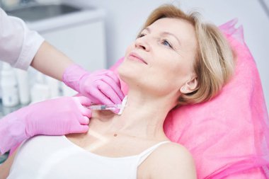 Olumlu keyifli olgun hasta güzellik prosedüründen zevk alıyor