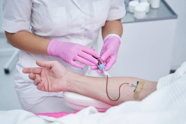 Uzman kozmetolojist hastasını ameliyata hazırlıyor.