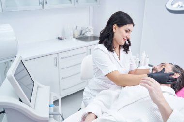 Memnun güzellik uzmanı hastasıyla iletişim kuruyor.