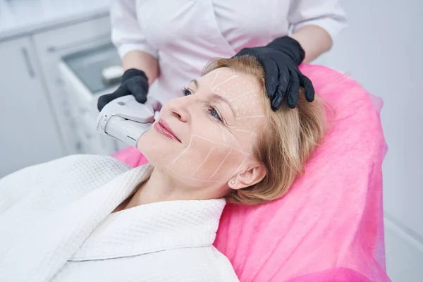 Cosmetologist performing SMAS lifting procedure in beauty salon — Stock Photo, Image