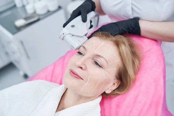 Mujer recibiendo tratamiento de lifting facial por ultrasonido en salón de belleza — Foto de Stock