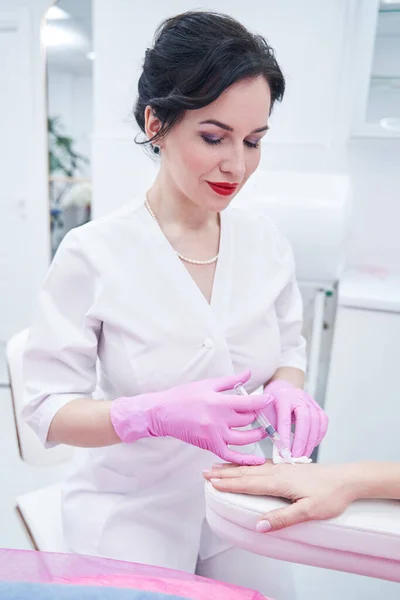 Cosmetologist encantado positivo que faz o procedimento de levantamento de pele — Fotografia de Stock