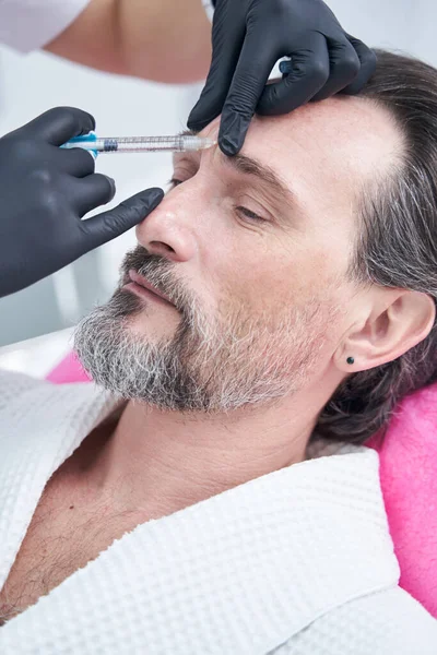 Competent cosmetologist doing injection to fill wrinkles — Stock Photo, Image