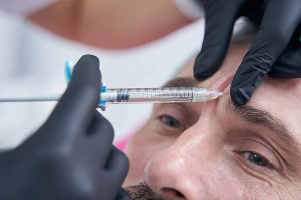 Close-up van mannelijke persoon die anti-rimpels injectie — Stockfoto