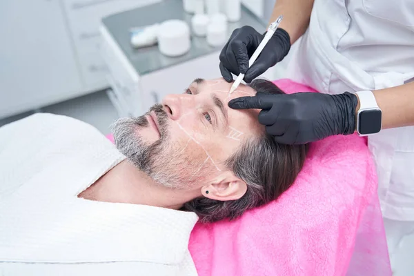 Yakışıklı sakallı adam yüzüne bakıyor.