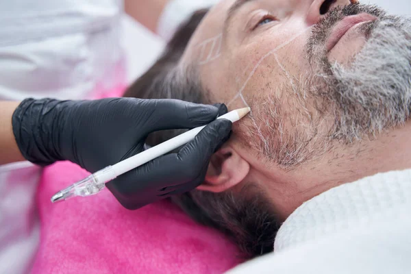 Yüzüne çizgiler çizen kozmetoloji uzmanına yakın dur.