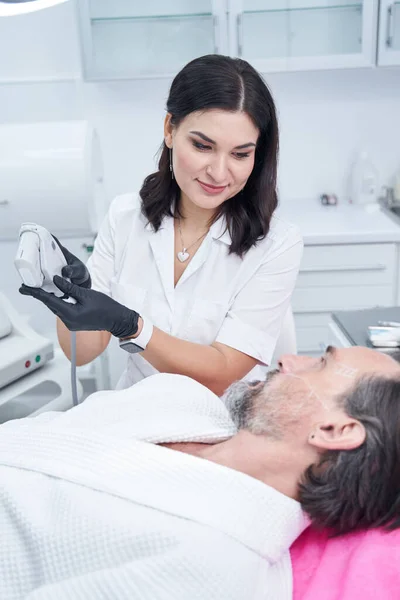 Kosmetolog positif senang Menunjukkan perangkat laser baru — Stok Foto