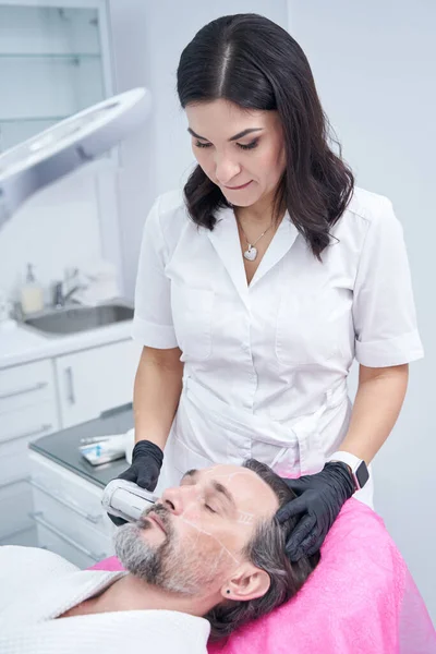 Serious beauty master doing course of laser procedure — Foto Stock
