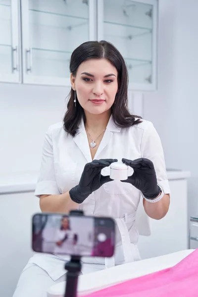 Young female person shooting video about cream — Zdjęcie stockowe