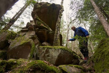 Yürüyüş sırasında yosunlu taşlardan inen erkek