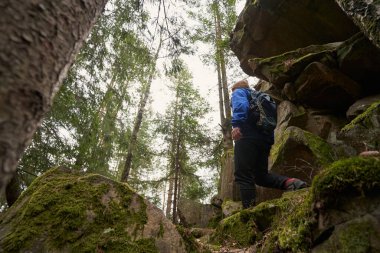 Orman kayalıklarında ilerlerken turist kameraya döndü