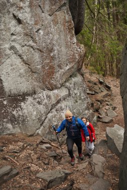 Sırt çantaları İskandinav direkleriyle köy yolunda yürüyor