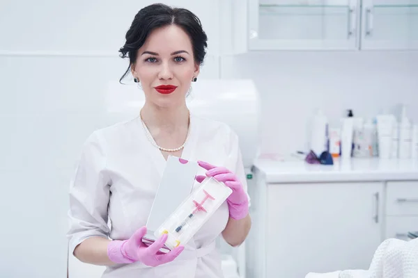 Esthéticienne femme avec seringue cosmétique debout dans un salon de beauté — Photo