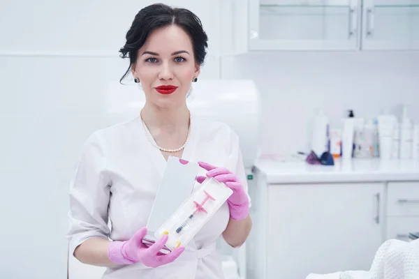 Woman beautician with cosmetic syringe standing in beauty salon — ストック写真